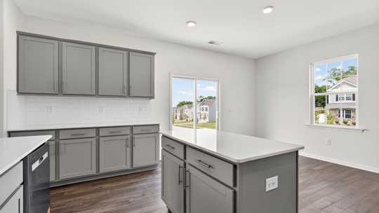 kitchen with quartz counters, kitchen island, pantry, stainless steel appliances