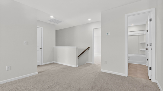 upstairs loft area with large windows and carpeting