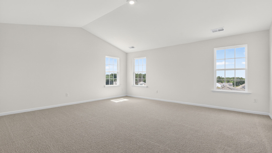primary bedroom with two windows and carpeting, attached bath