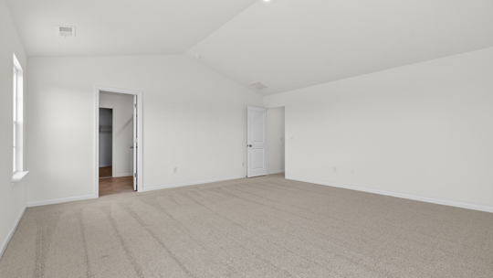 primary bedroom with two windows and carpeting, attached bath