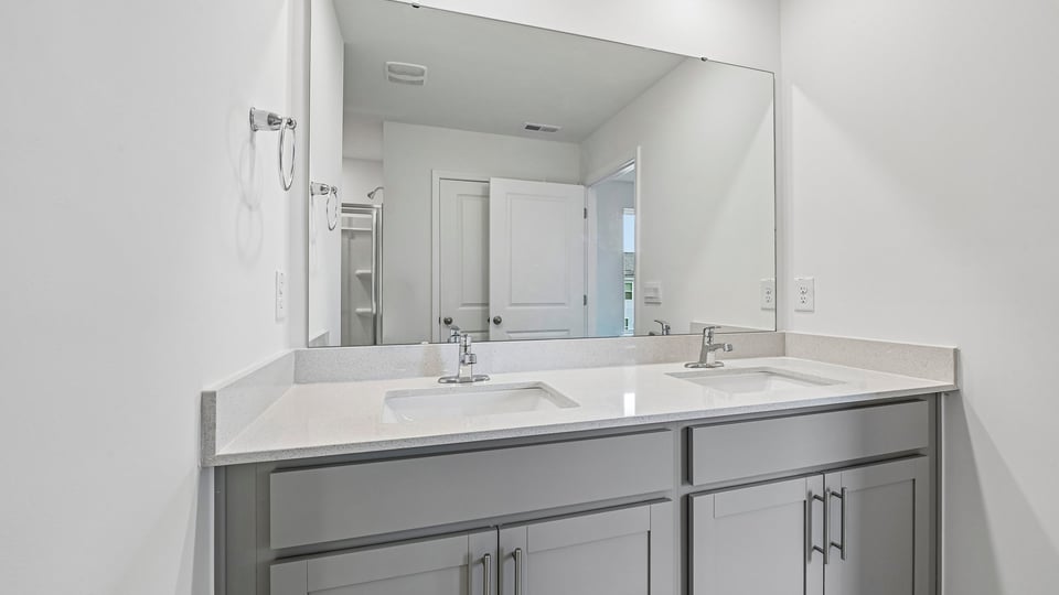 bathroom with dual vanity sinks and quartz countertops