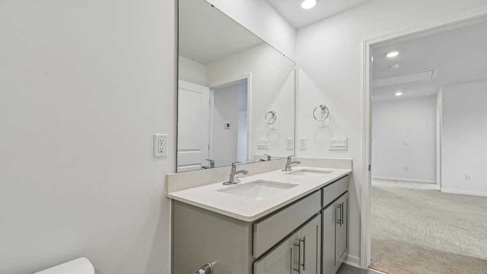 bathroom with single sink quartz countertops and gray cabinets