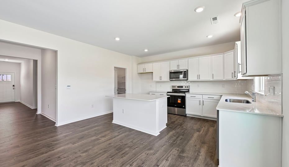 kitchen with white cabinets center island and quartz countertops