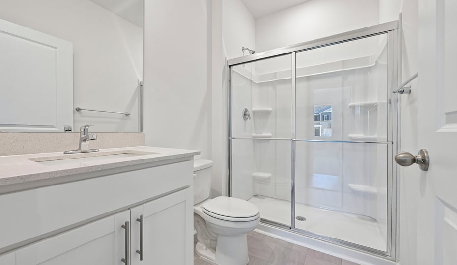 bathroom with quartz countertops and walkin glass door shower