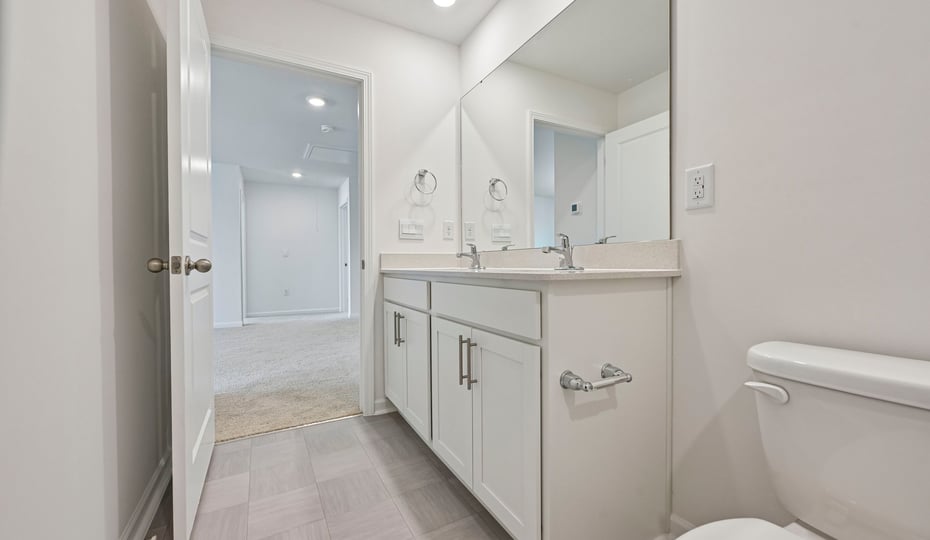 bathroom with white cabinets and quartz countertops