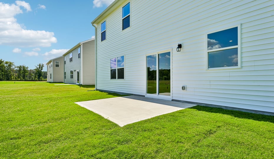 back of home with concrete patio