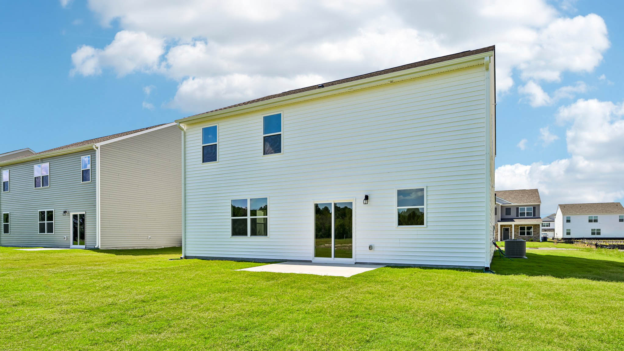 back of home with concrete patio