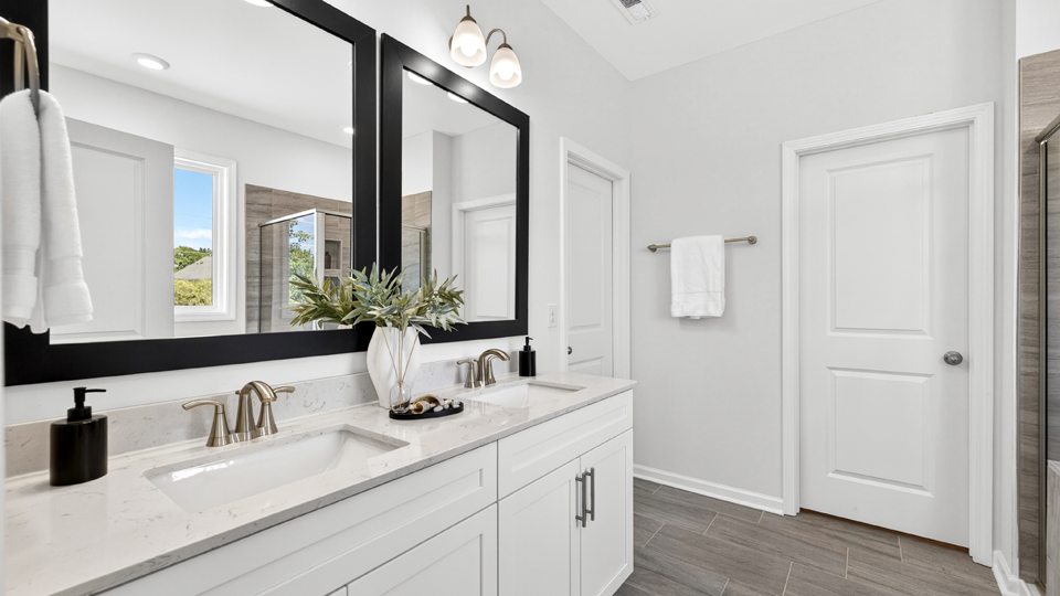 primary bathroom with walk in shower, bathtub, and dual vanity sinks