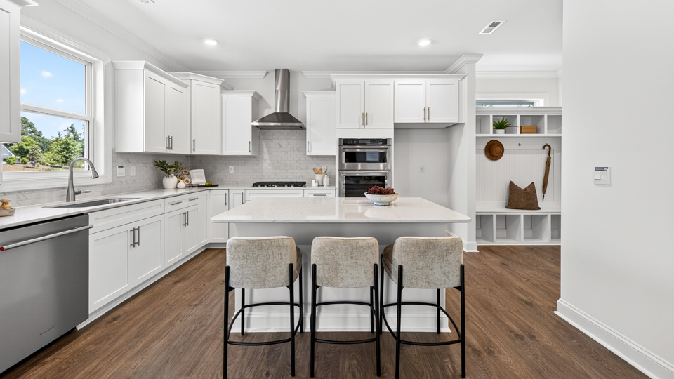 kitchen with quartz counters, kitchen island, pantry, stainless steel appliances