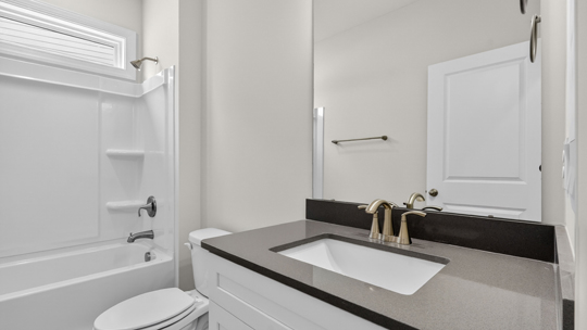 secondary bathroom with shower tub combo and single vanity sink