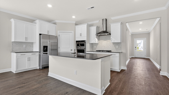 kitchen with quartz counters, kitchen island, pantry, stainless steel appliances