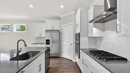 kitchen with quartz counters, kitchen island, pantry, stainless steel appliances