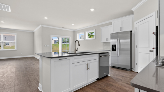 kitchen with quartz counters, kitchen island, pantry, stainless steel appliances