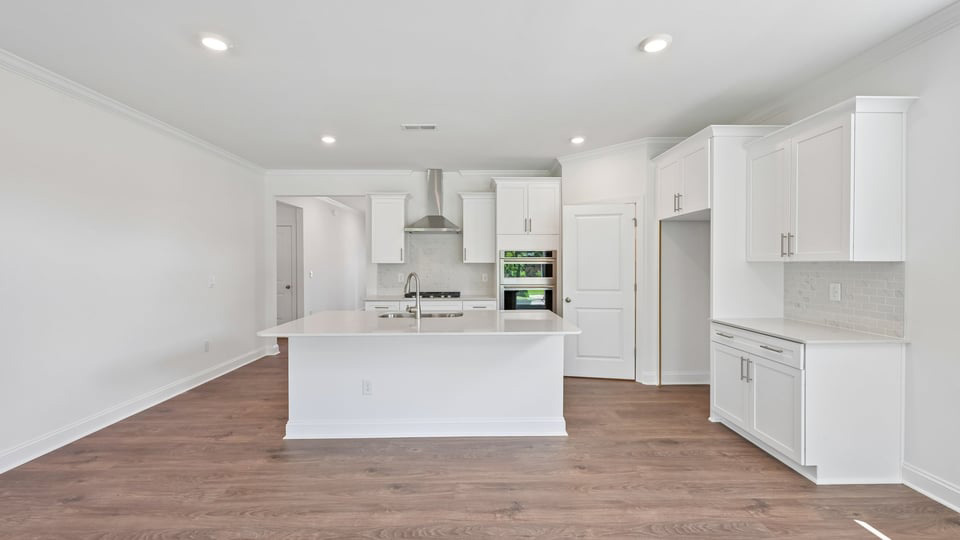 kitchen with quartz counters, kitchen island, pantry, stainless steel appliances