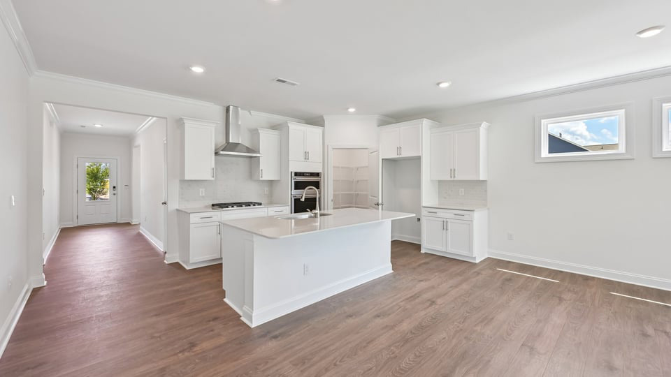 kitchen with quartz counters, kitchen island, pantry, stainless steel appliances