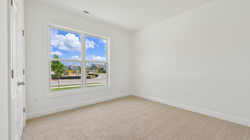 secondary bedroom with window and closet, carpeting