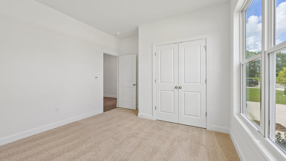 secondary bedroom with window and closet, carpeting