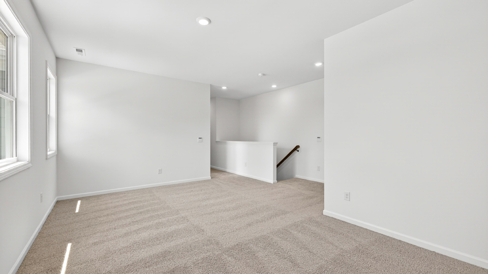 upstairs loft area with large windows and carpeting