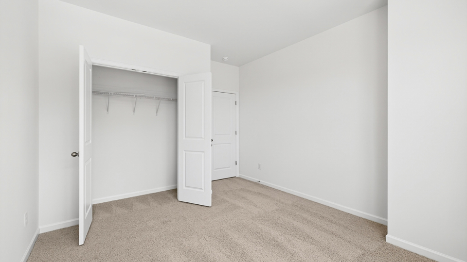 secondary bedroom with window and closet, carpeting