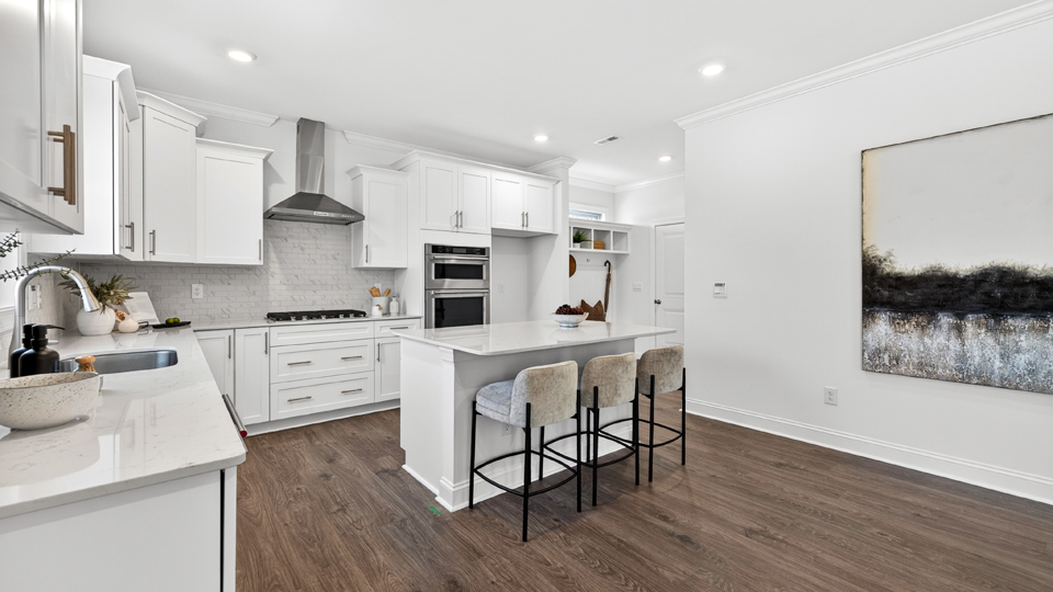 kitchen with quartz counters, kitchen island, pantry, stainless steel appliances