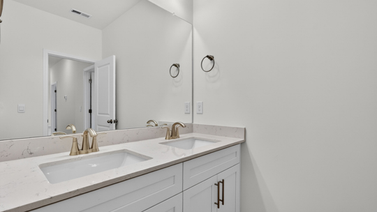 bathroom with white cabinets and quartz countertops