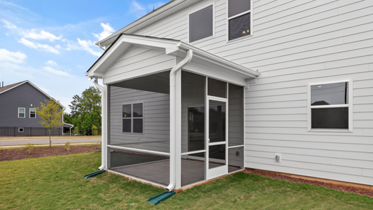 back of home with covered and screened in patio