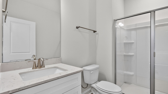 bathroom with walkin shower and quartz countertops