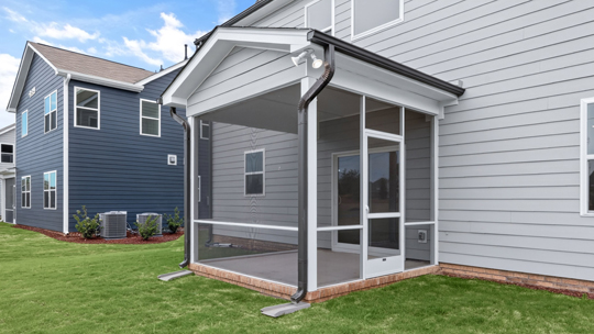 back of home with covered and screened in patio