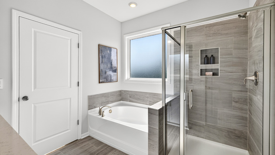 primary bathroom with separate tub and walkin shower
