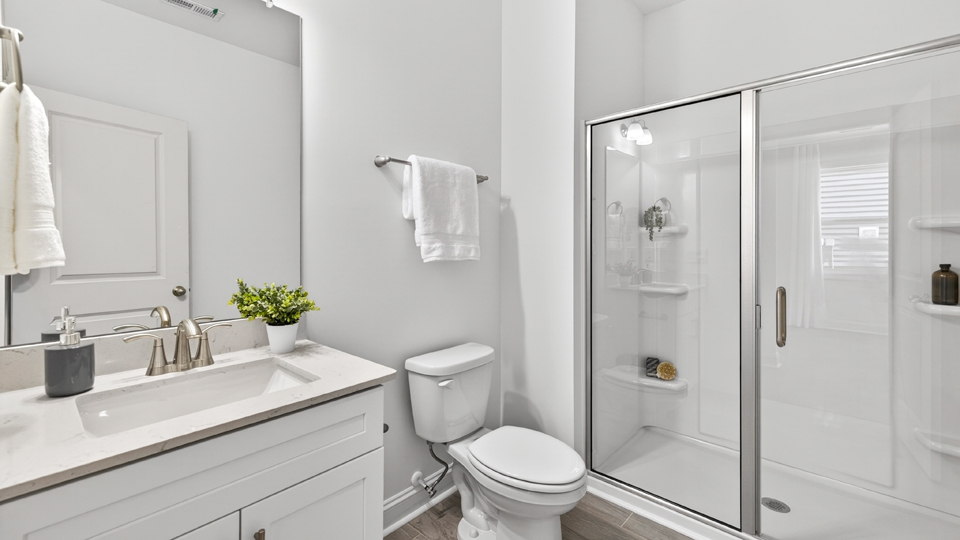 secondary bathroom with walk in shower and single vanity sink