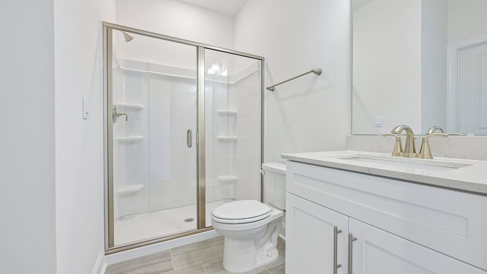 bathroom with walkin shower and white cabinets