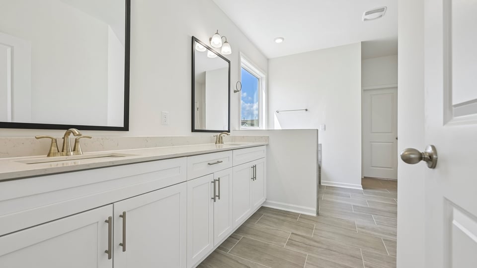 bathroom with dual vanity white cabinets and quartz countertops
