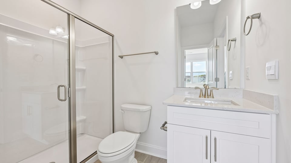 bathroom with walkin shower and white cabinets