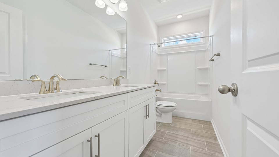 bathroom with dual vanity and tub shower combo