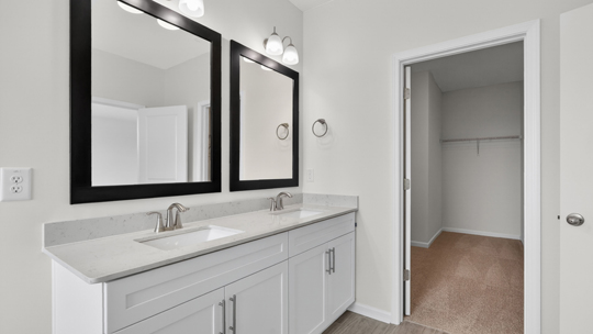 bathroom with dual vanity and quartz countertops