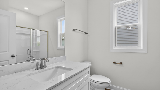 bathroom with quartz countertops and window