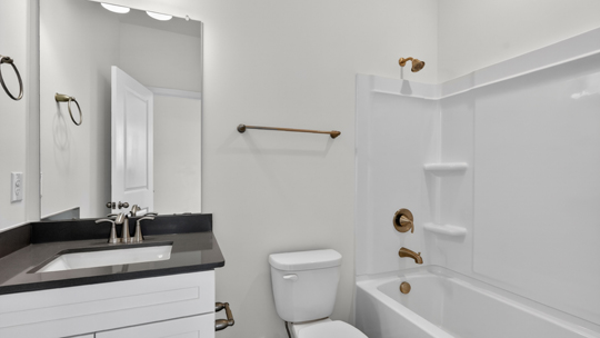 bathroom with quartz countertops and tub shower combo