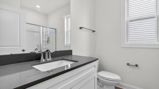 bathroom with quartz countertops and window