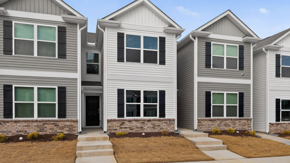 Two story town home with white siding.