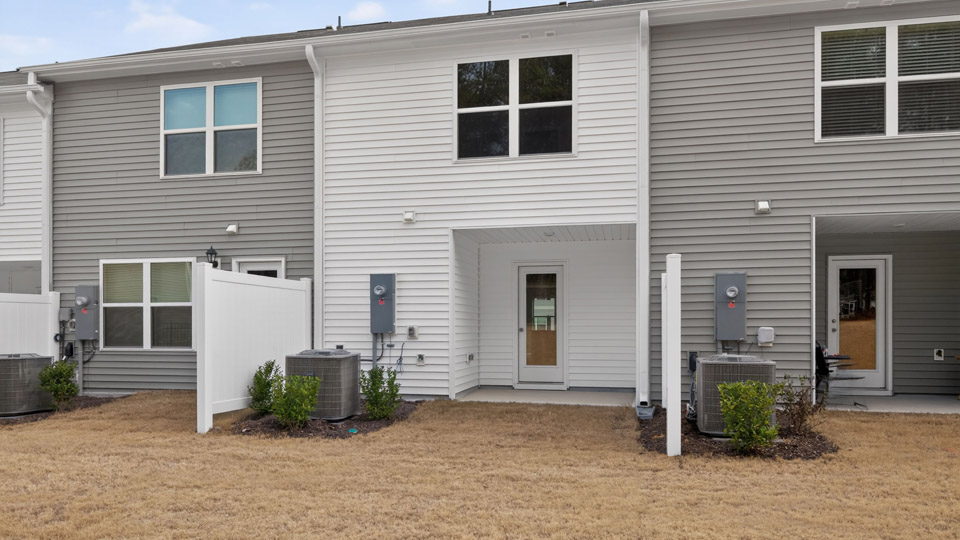 Two story town home with white siding.
