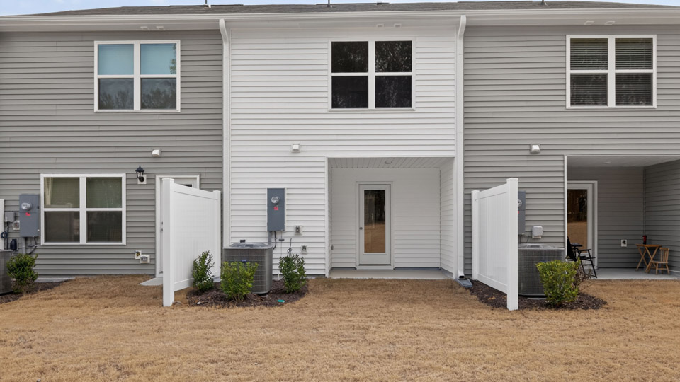 Two story town home with white siding.