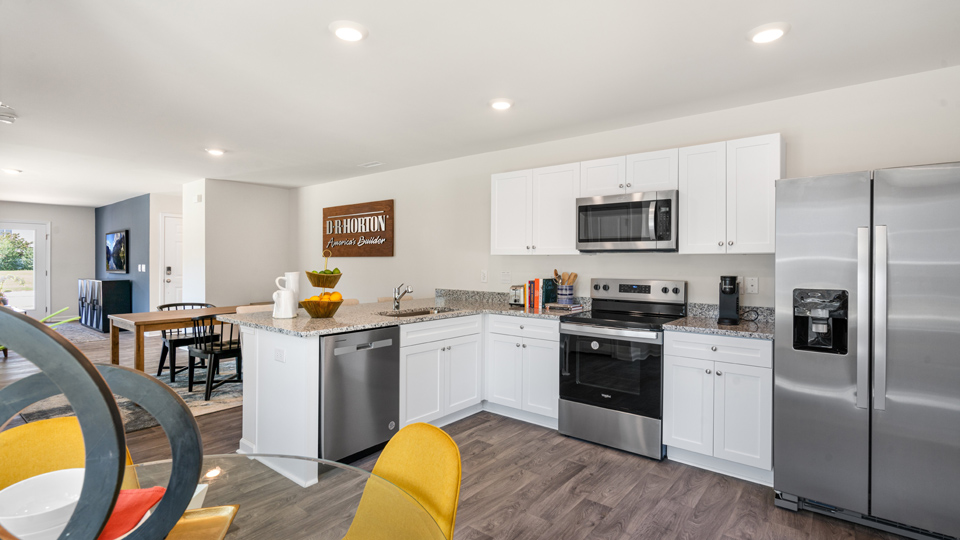 kitchen with stainless steel appliances, granite countertops and vinyl flooring