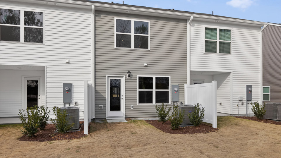 Two story town home with gray siding & Back yard area