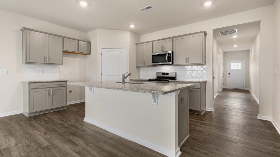 kitchen with quartz counters, kitchen island, pantry, stainless steel appliances