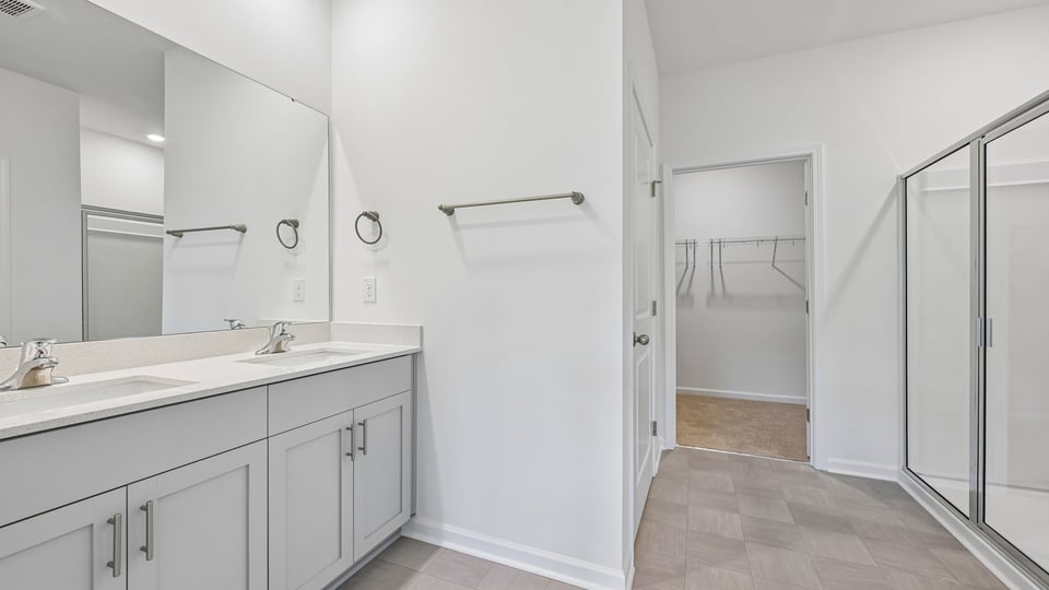 primary bathroom with dual vanity and walkin shower