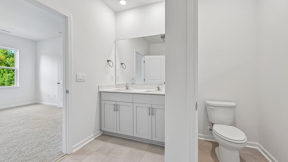primary bathroom with water closet and dual vanity