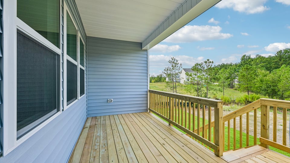 covered back deck and treelined backyard