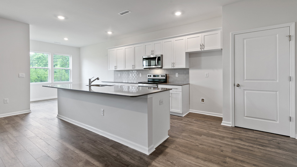kitchen with quartz counters, kitchen island, pantry, stainless steel appliances