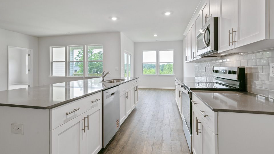 kitchen with quartz counters, kitchen island, pantry, stainless steel appliances