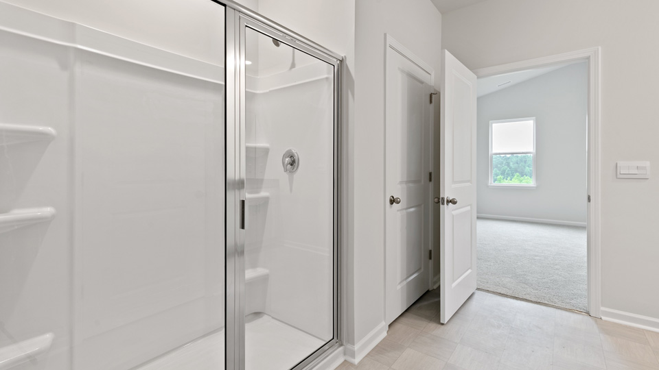 primary bathroom with walk in shower and dual vanity sinks